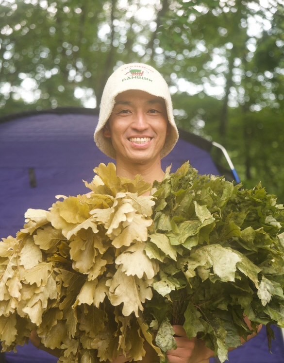 植物の束を持つ吉田さん
